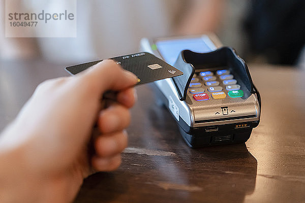 Mann zahlt mit Kreditkarte im Restaurant