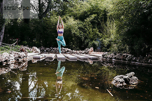Mittlere erwachsene Frau macht Yoga im öffentlichen Park