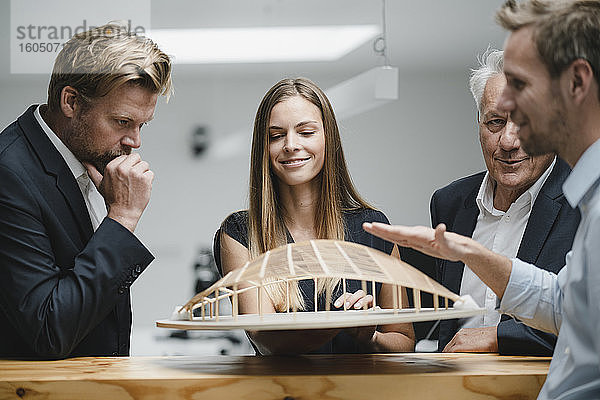 Erfolgreiche Geschäftsleute betrachten das architektonische Modell im Büro