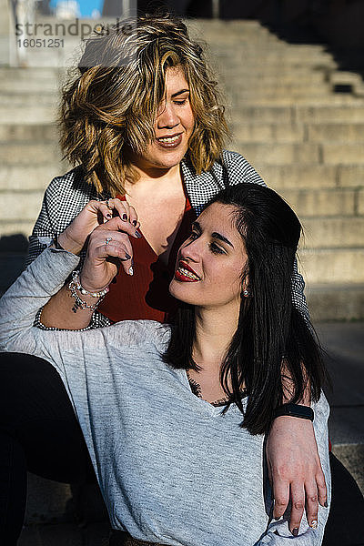 Nahaufnahme eines lesbischen Paares  das auf einer Treppe in der Stadt sitzt