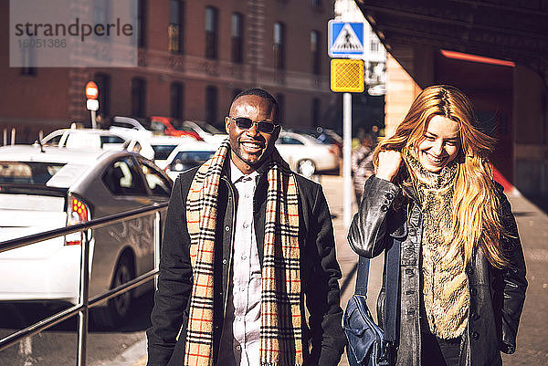 Lächelnde stilvolle Kollegen auf der Straße in der Stadt