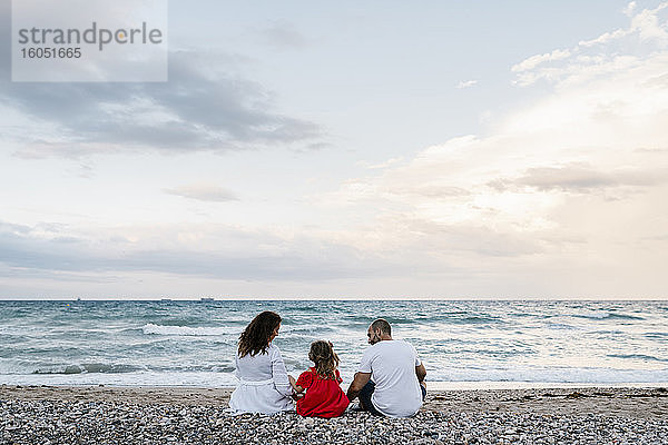 Familie verbringt Zeit am Strand bei bewölktem Himmel