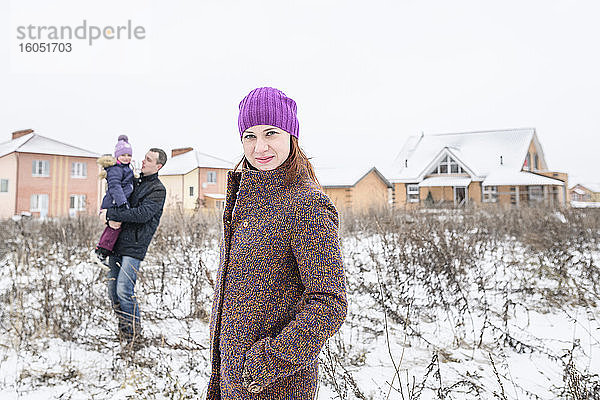 Schöne Frau mit Vater und Tochter im Hintergrund im Winter