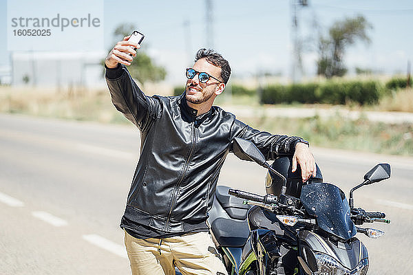 Biker mit Motorrad machen ein Selfie