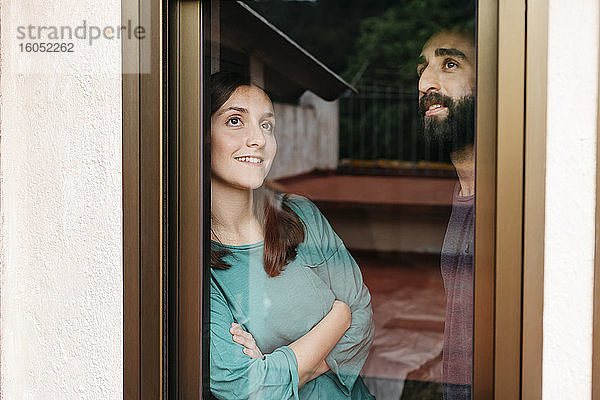 Ein Paar schaut aus dem Fenster und denkt an die Zukunft
