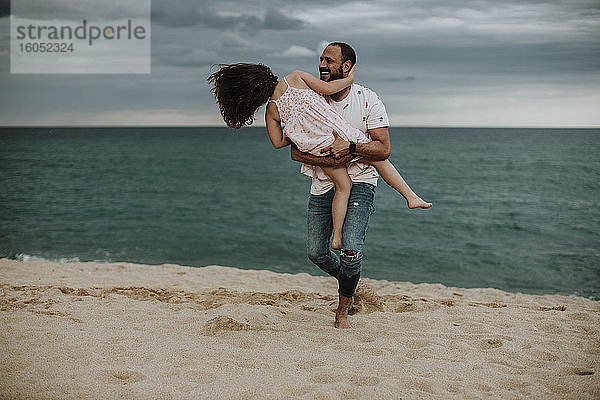 Glücklicher Vater mit Tochter am Strand