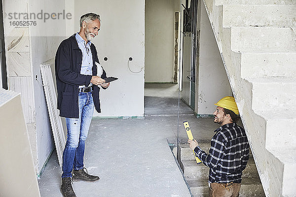 Lächelnder Architekt und Arbeiter auf einer Baustelle