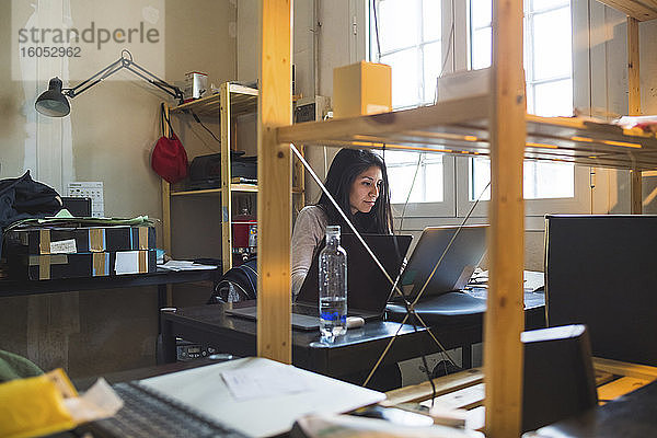 Frau mit Laptop am Schreibtisch im Büro