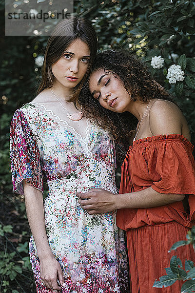 Zwei schöne Frauen umarmen sich in der Natur