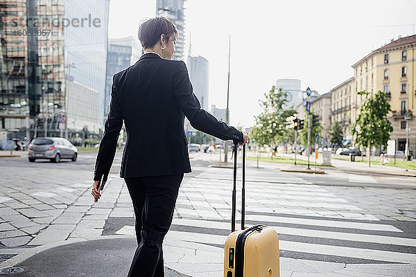 Unternehmerin mit Koffer auf der Straße in der Stadt