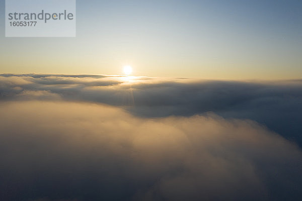 Drohnenansicht der aufgehenden Sonne über dichtem Nebel