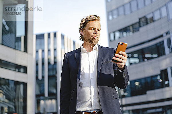 Geschäftsmann mit Smartphone in der Stadt