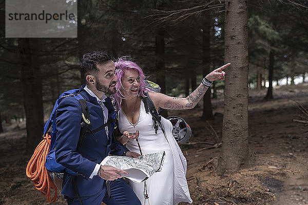 Brautpaar mit Wanderkarte im Wald