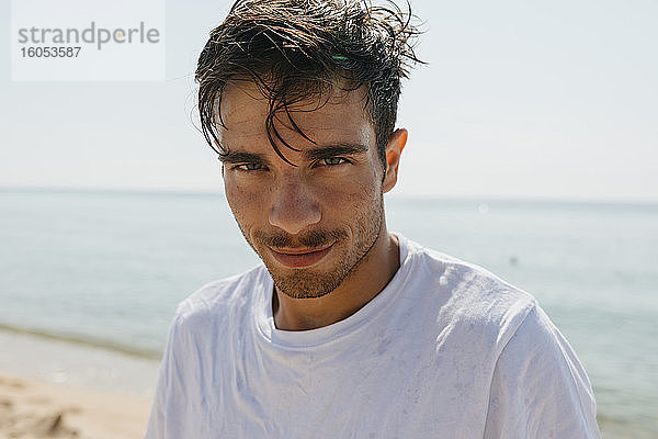 Nahaufnahme eines gut aussehenden jungen Mannes am Strand an einem sonnigen Tag