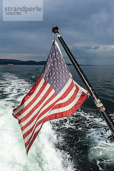 USA  Washington  amerikanische Flagge auf dem Rücken eines fahrenden Motorboots