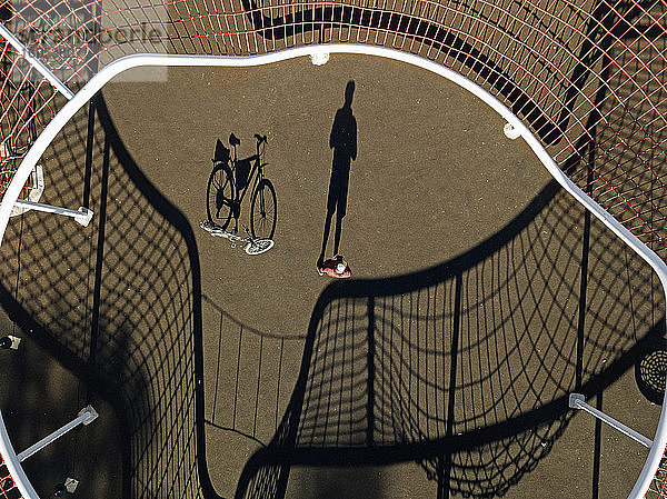 Mann mit Fahrrad auf Sportplatz  Luftaufnahme