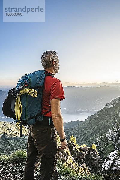 Wanderer mit Rucksack und Blick auf die Berge gegen den klaren Himmel bei Sonnenuntergang  Orobie  Lecco  Italien