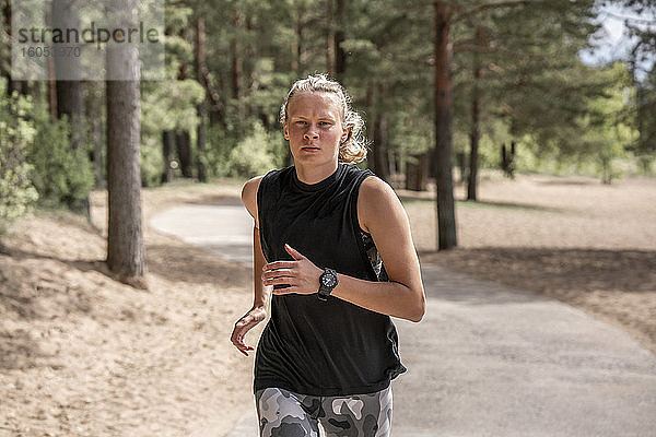 Junge blonde Frau joggt im Wald