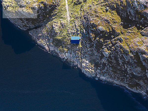 Luftaufnahme einer abgelegenen Hütte am felsigen Ufer der Barentssee
