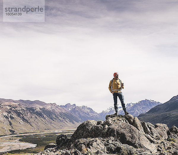 Älterer männlicher Wanderer auf einem Felsen stehend gegen den Himmel in Patagonien  Argentinien