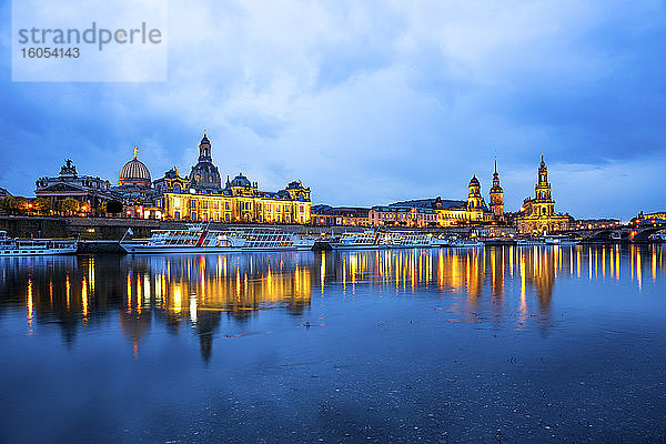 Deutschland  Sachsen  Dresden  Ausflugsboote am Elbufer in der Abenddämmerung mit der Skyline der Stadt im Hintergrund