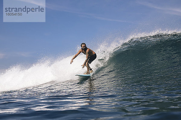 Hemdsärmeliger erwachsener Mann beim Surfen auf dem Meer gegen den Himmel  Bali  Indonesien
