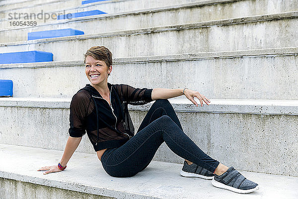 Sportliche Frau auf der Treppe sitzend