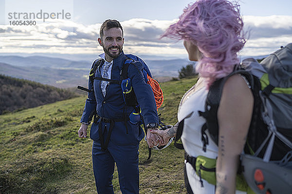Brautpaar mit Kletterrucksäcken vor dem Berg Urkiola  Spanien