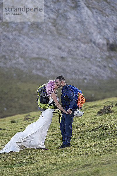 Küssendes Brautpaar mit Kletterrucksäcken  Berg Urkiola  Spanien