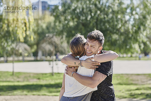 Ein sich umarmendes Paar vor dem Training im Park
