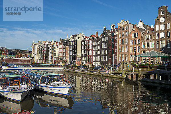 Niederlande  Provinz Nordholland  Amsterdam  Damrak  Ausflugsschiffe und Hafengebäude