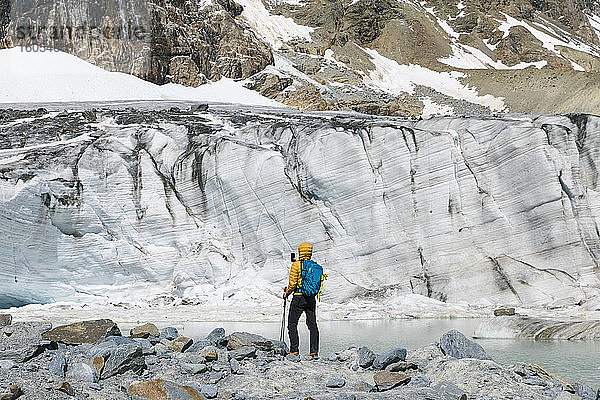 Mann beim Wandern mit Blick auf den schmelzenden Gletscher