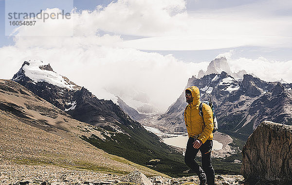 Mann geht auf Berg gegen bewölkten Himmel  Patagonien  Argentinien