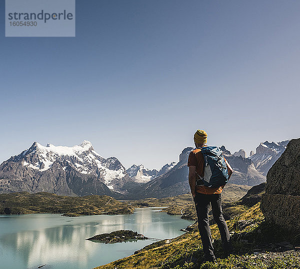 Mann mit Rucksack schaut auf einen See gegen den klaren Himmel  Torres Del Paine National Park  Patagonien  Chile