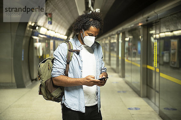 Junger Mann mit Schutzmaske auf dem Bahnsteig einer U-Bahn-Station  London  UK