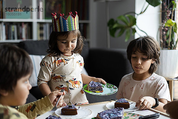 Porträt eines kleinen Mädchens  das mit seiner Familie zu Hause Geburtstag feiert