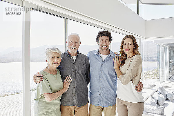 Porträt eines glücklichen älteren Paares mit erwachsenen Kindern in einer Luxusvilla
