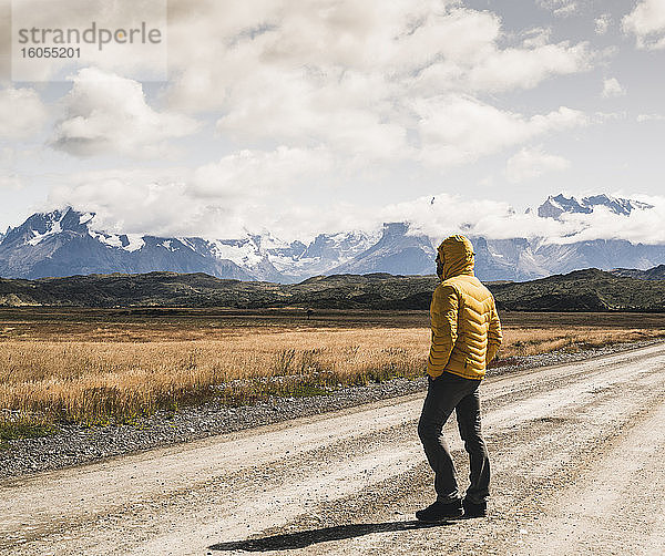 Mann auf unbefestigter Straße vor bewölktem Himmel im Torres Del Paine National Park  Patagonien  Chile