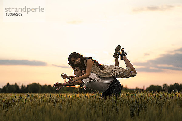 Tanzendes Paar auf einem Feld bei Sonnenuntergang