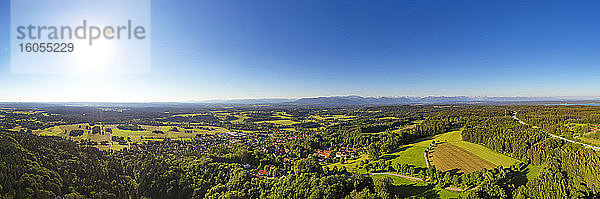 Deutschland  Bayern  Eurasburg  Luftbildpanorama mit Sonnenschein über einem Dorf im Alpenvorland