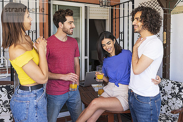 Glückliche junge Freunde unterhalten sich im Hinterhof