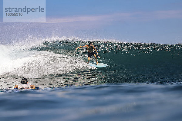 Mann ohne Hemd beim Surfen auf dem Meer gegen den Himmel  Bali  Indonesien