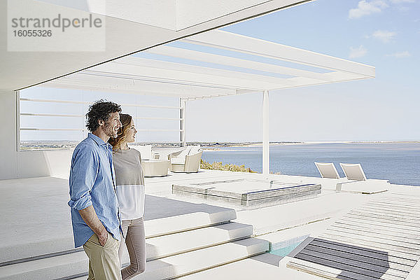 Paar in luxuriösem Strandhaus genießt die Aussicht