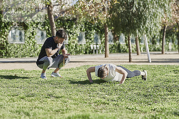 Frau beim Workout mit Trainer im Park