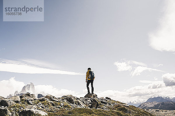 Wanderer mit Rucksack auf einem Berg stehend gegen den Himmel an einem sonnigen Tag  Patagonien  Argentinien
