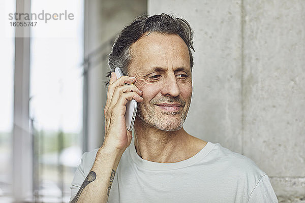 Porträt eines älteren Mannes am Telefon in einer Dachgeschosswohnung