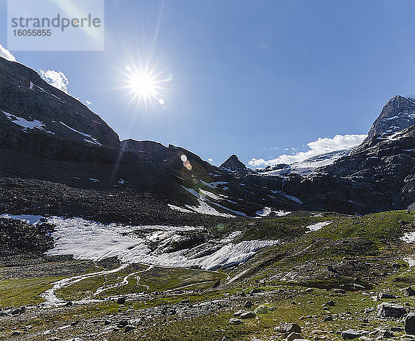 Landschaftliche Ansicht einer Bergkette mit schmelzenden Gletscherströmen gegen den Himmel an einem sonnigen Tag