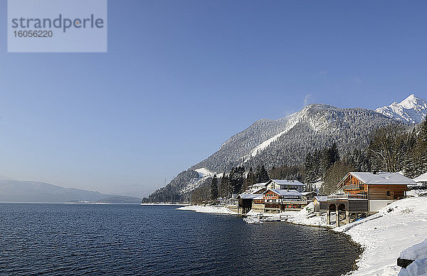 Deutschland  Bayern  Häuser am schneebedeckten Ufer des Walchensees