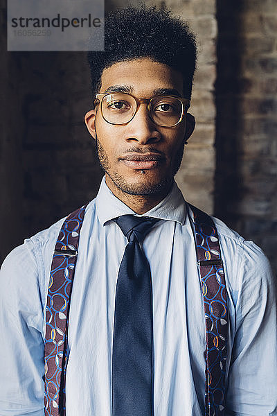 Porträt eines stilvollen jungen Mannes mit Hemd  Krawatte und Hosenträgern