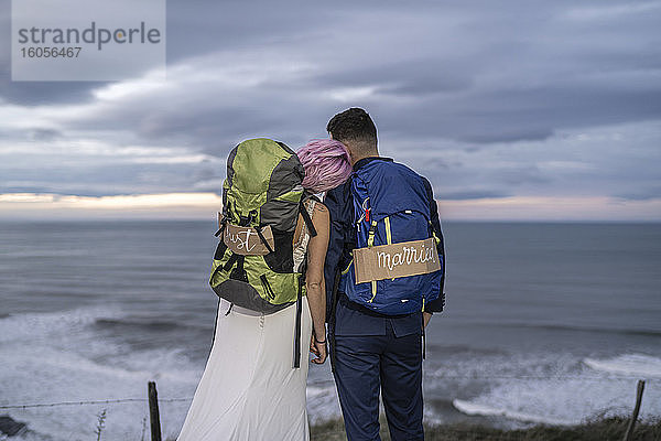 Brautpaar auf Aussichtspunkt und Meer im Hintergrund